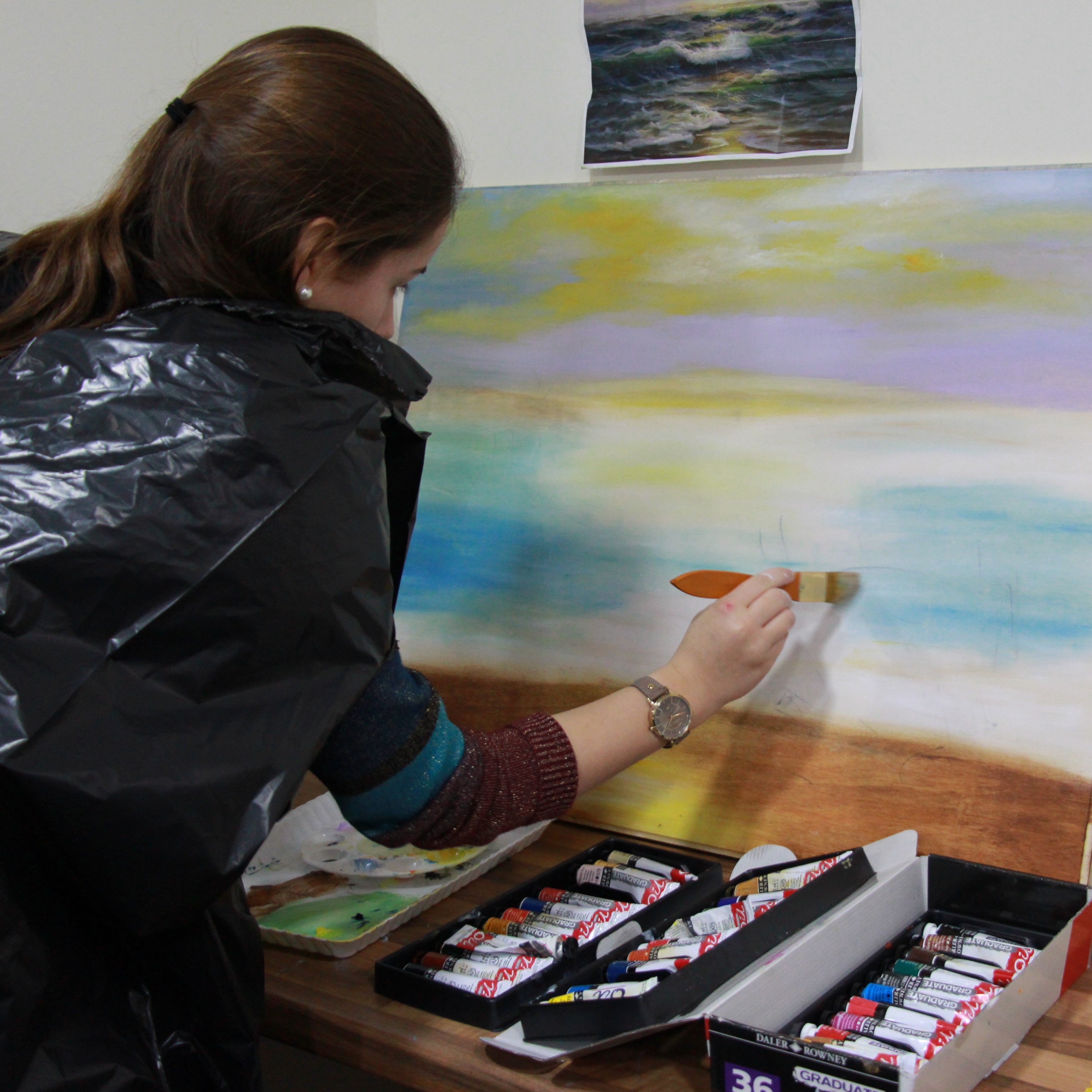 Young woman painting on a canvas.