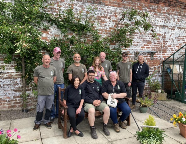 Staff and volunteers standing in front of apple trees.