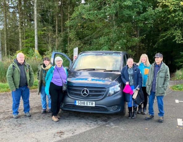 Individuals standing either side of a vehicle