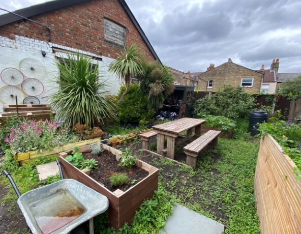 Garden with a large planter, long table and bench seating