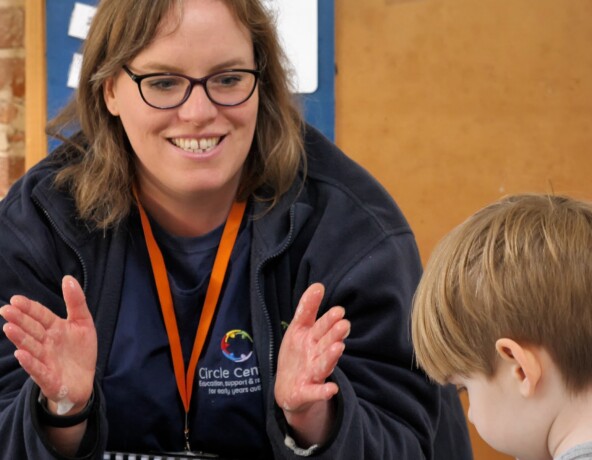 Team member clapping to engage a young boy