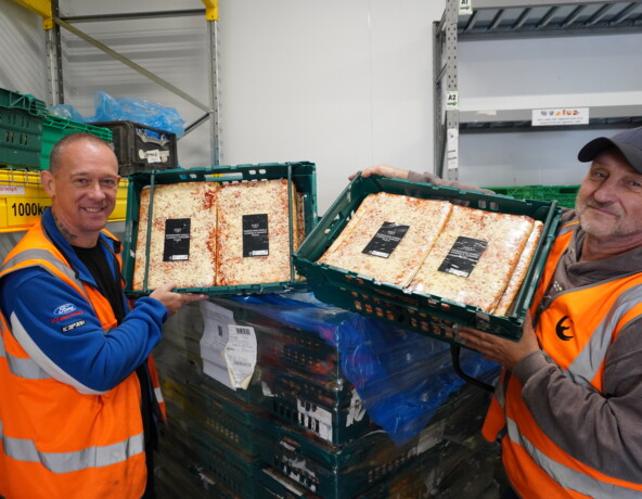 Volunteers holding square pizzas