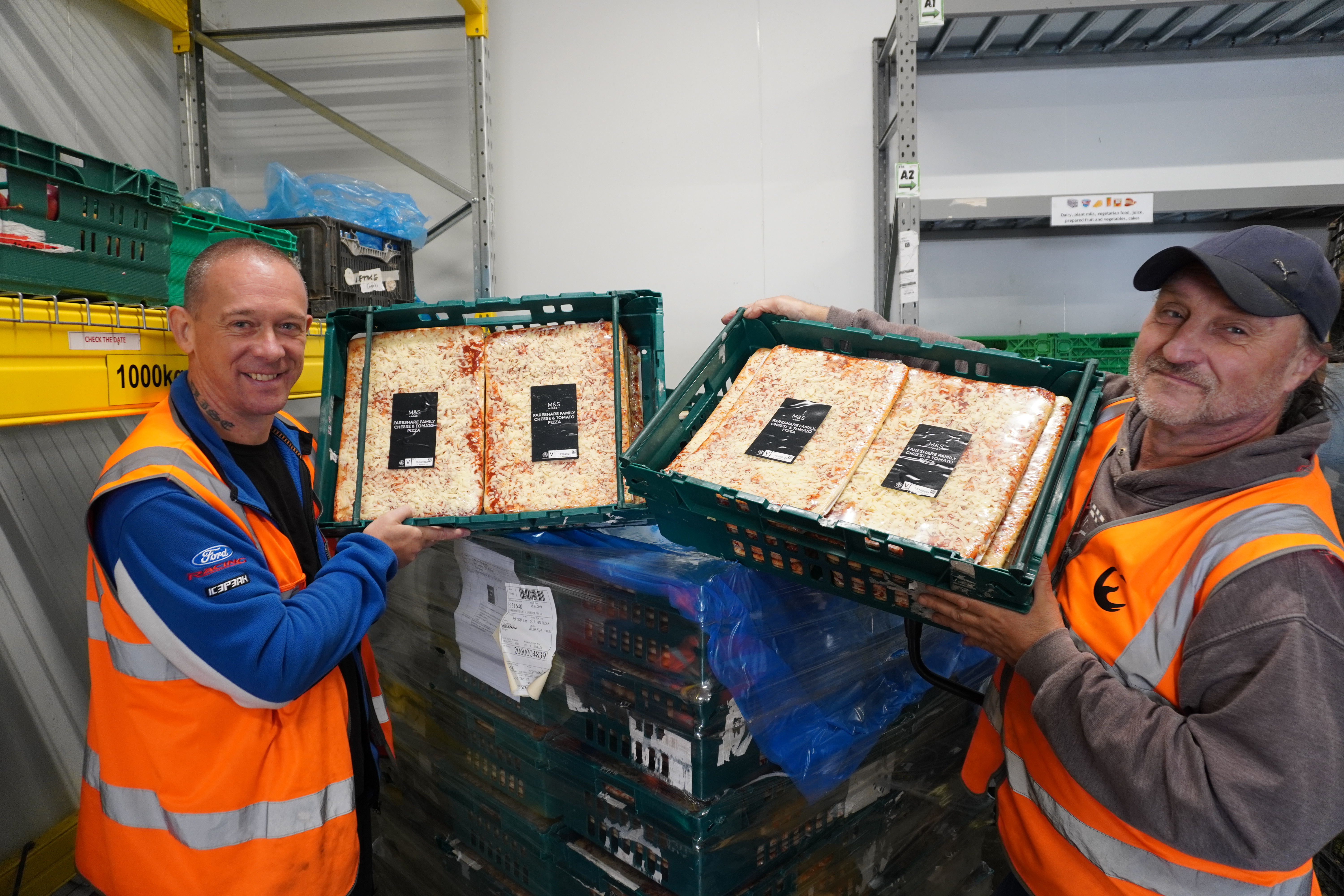 Volunteers holding square pizzas